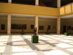 A lone statue stands in a barren room.