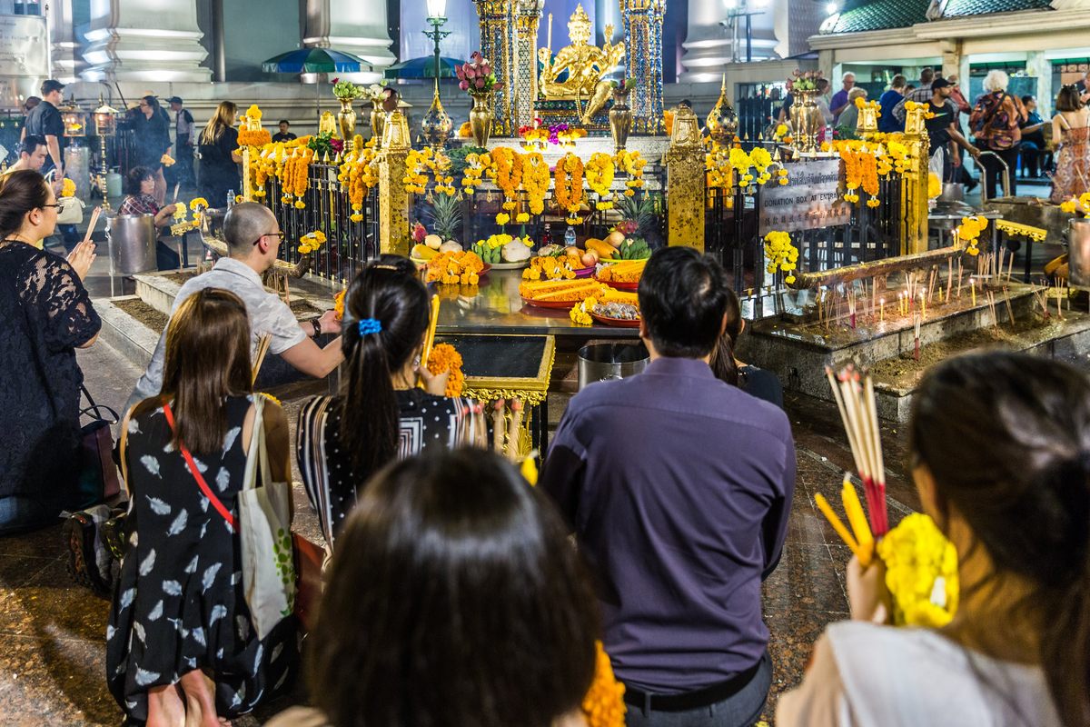 At Erawan Shrine in Bangkok, worshippers pay their respects to a statue of Brahma.