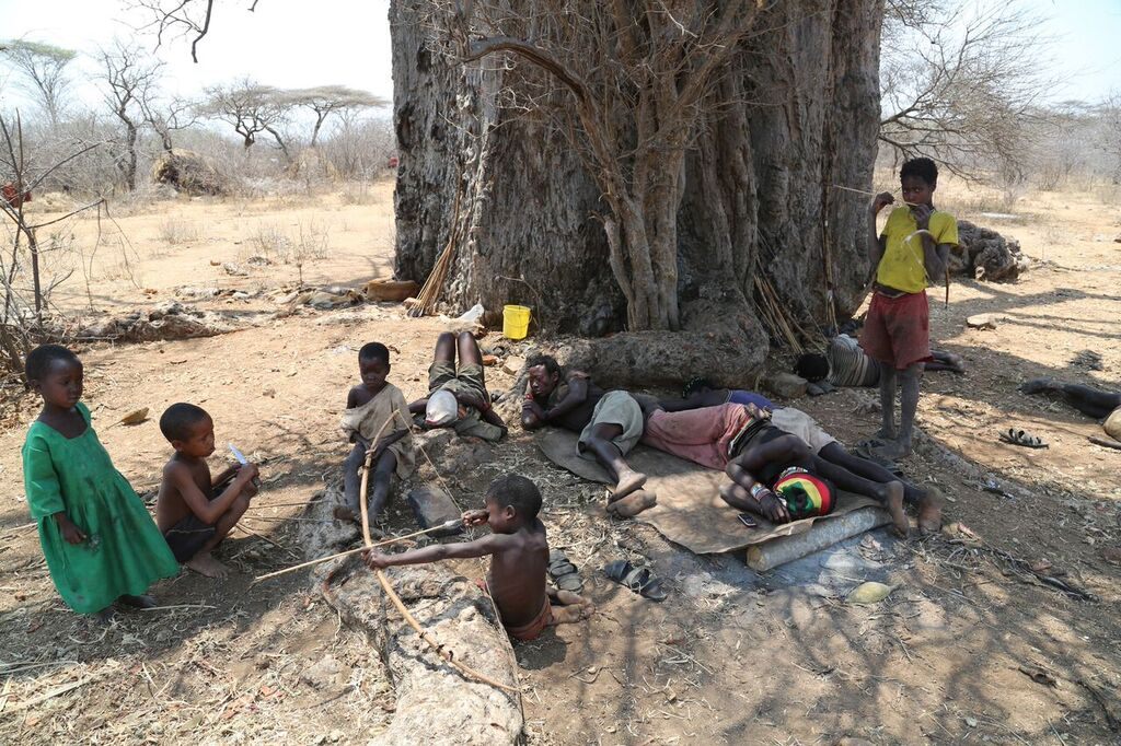 Hadza people hanging out under a tree.