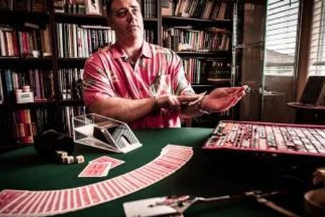 Conjurer Jason England teaches a card trick.