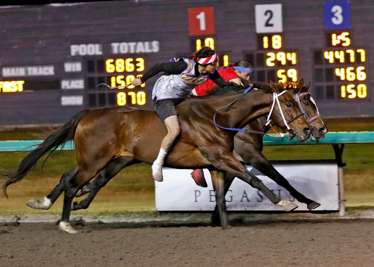 Riders Azeri Coby (foreground) and Darren Charges Strong (in red) duel it out in an Indian Relay race at Emerald Downs in Auburn, Washington.