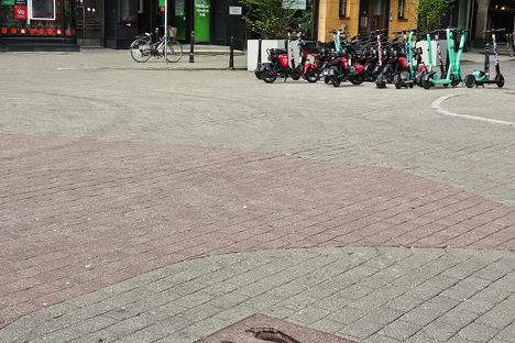 The Baltic Way footprints with some electric scooters in the background.
