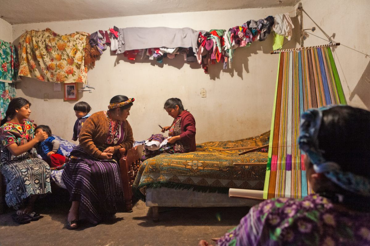 Sofia Ixcot Xivir (back to the camera, in the bottom right corner) with her daughters, a neighbor, and her grandchildren at her home in Zunil.
