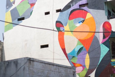 Colorful faces peer down from a residential complex.