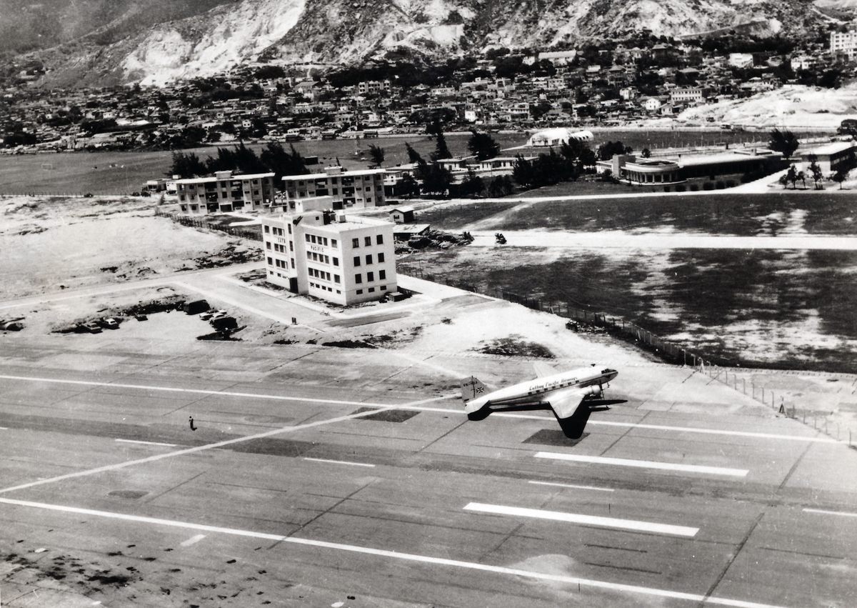 Cathay Pacific Airways Douglas DC-3 outside the airlines headquarters and stores building, Kai Tak Airport, 1959.