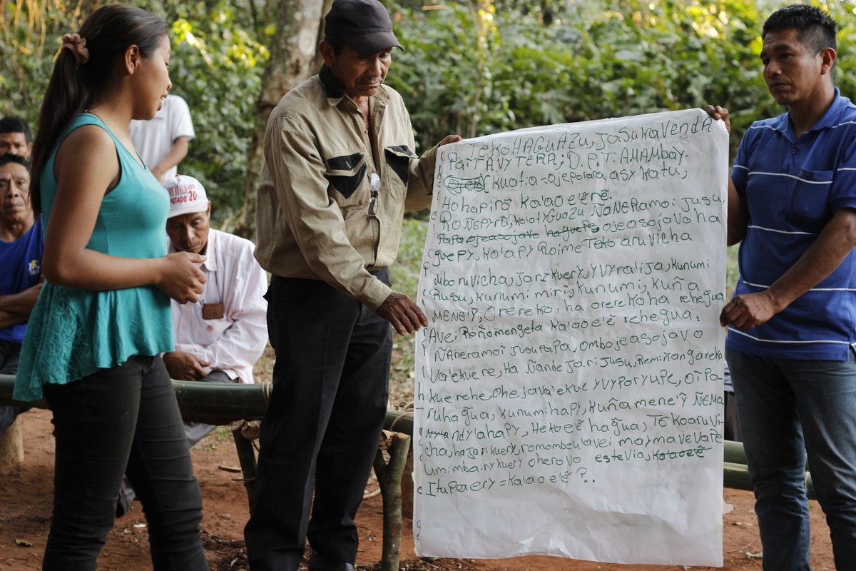 Guaraní stand in front of a declaration directed toward Coca-Cola and other companies profiting from stevia.