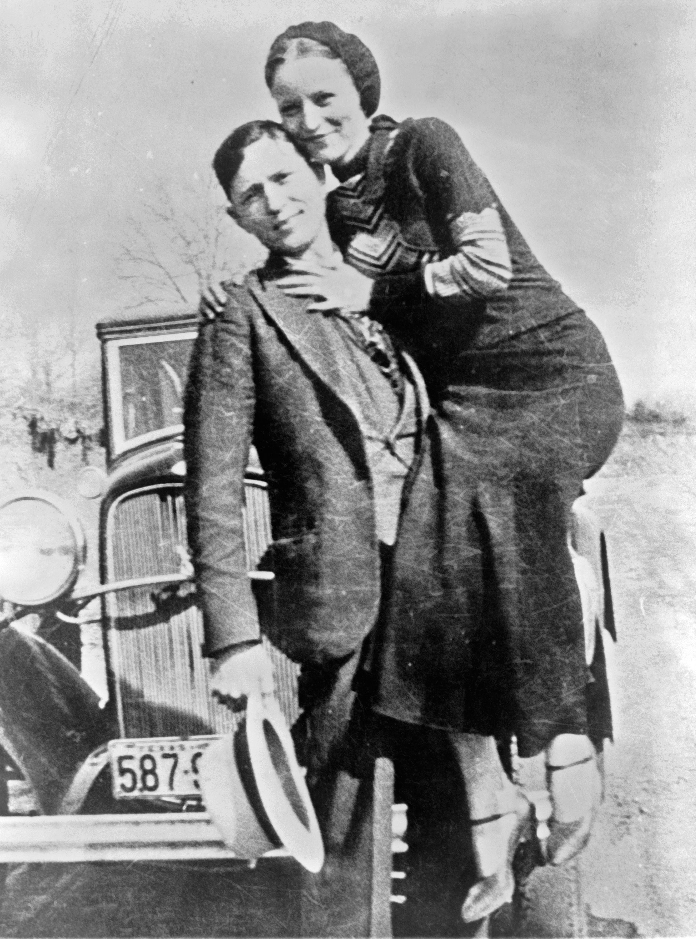Bonnie and Clyde, embracing.