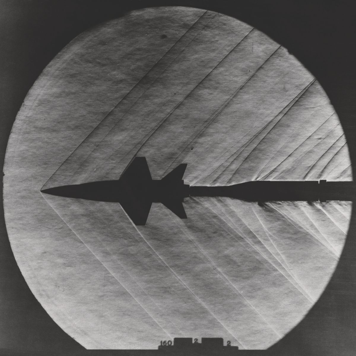 Shock waves emerge from a small-scale model of the X-15 rocket-powered aircraft in the 4 x 4–Foot Supersonic Pressure Tunnel, 1962.
