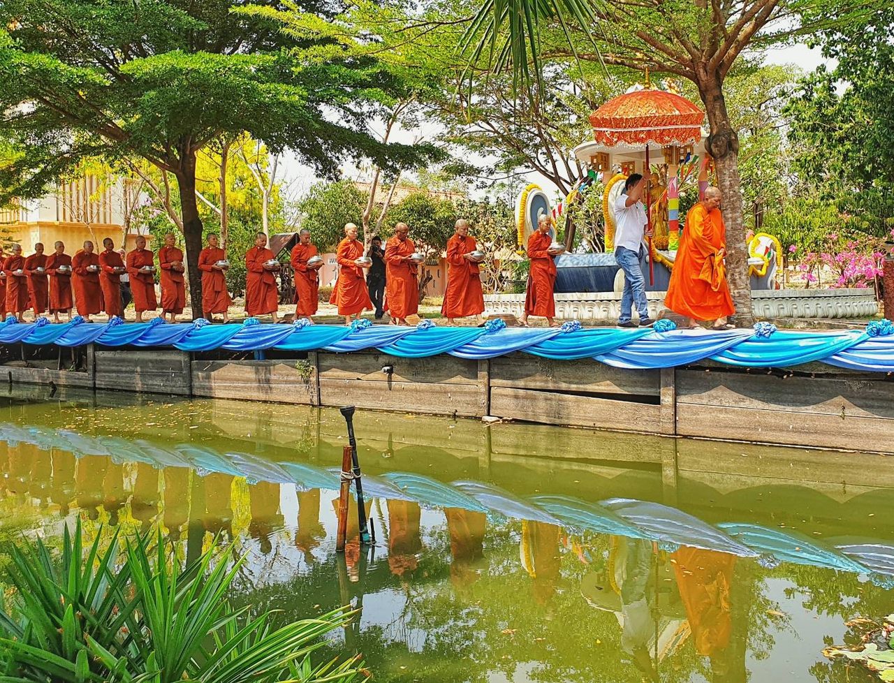 The monks collect alms in Nakhon Pathom province.

