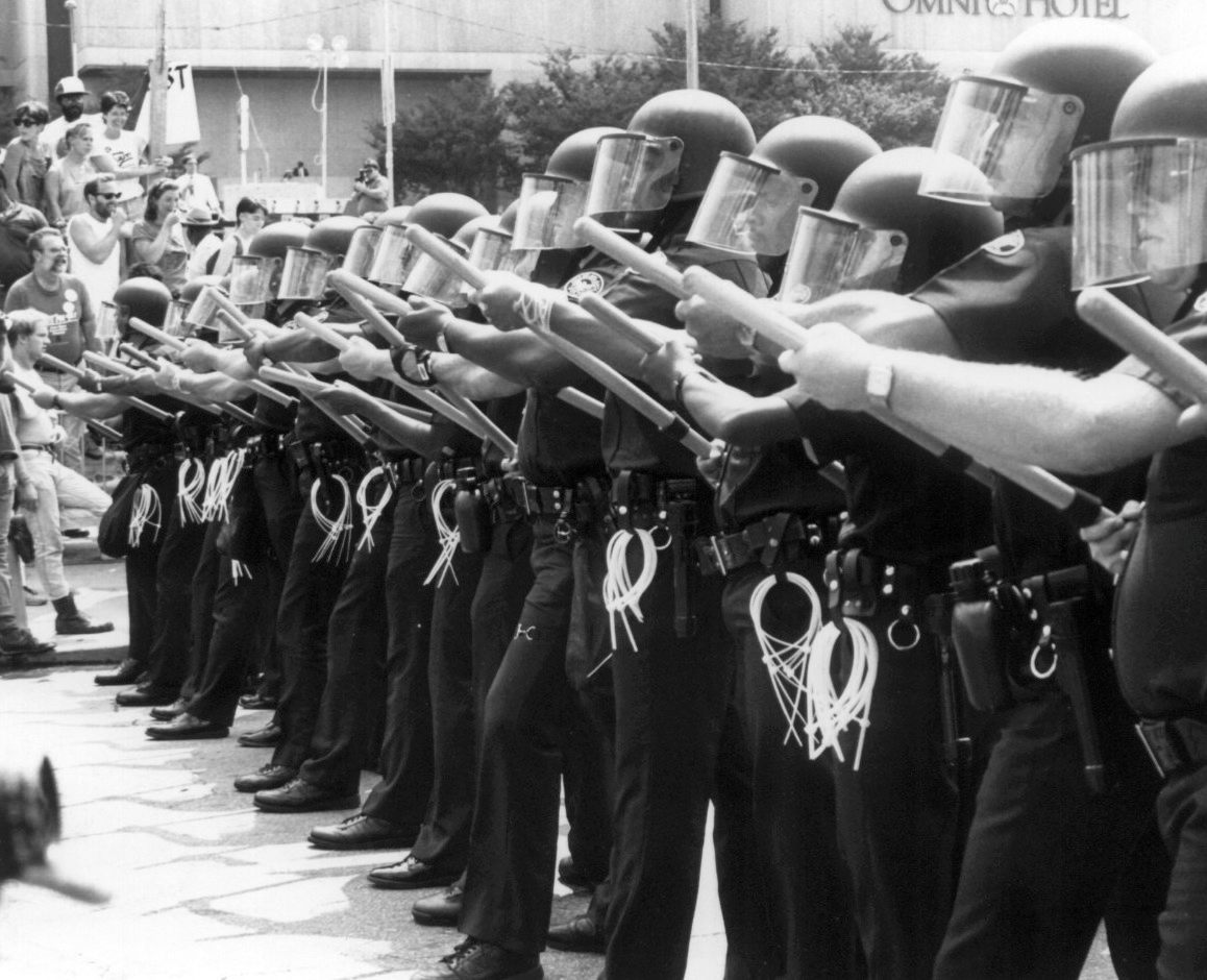 Police form a line against ACT UP protestors outside the 1988 Republican National Convention in New Orleans.