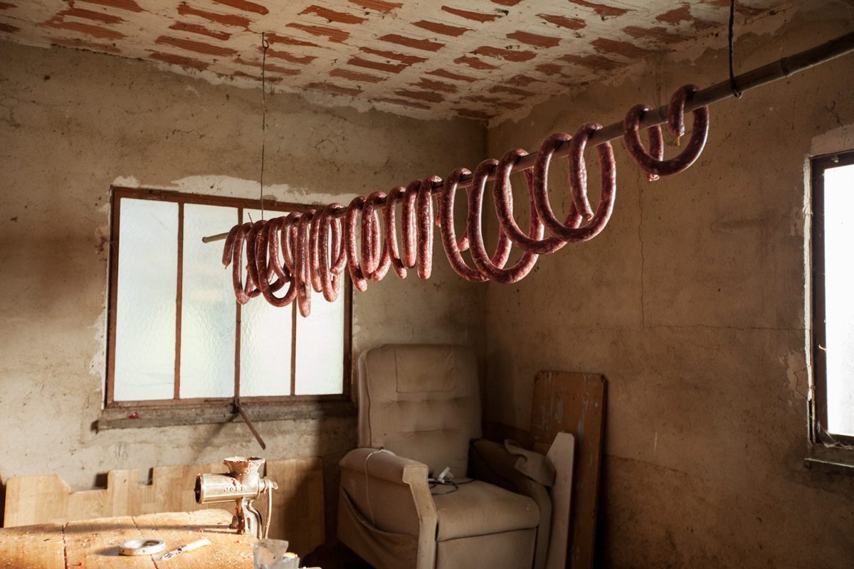 Saucisse hangs to dry in the garage. The meat is ground by hand and salt, pepper, and fat are added based on a recipe that has been passed down through the family.