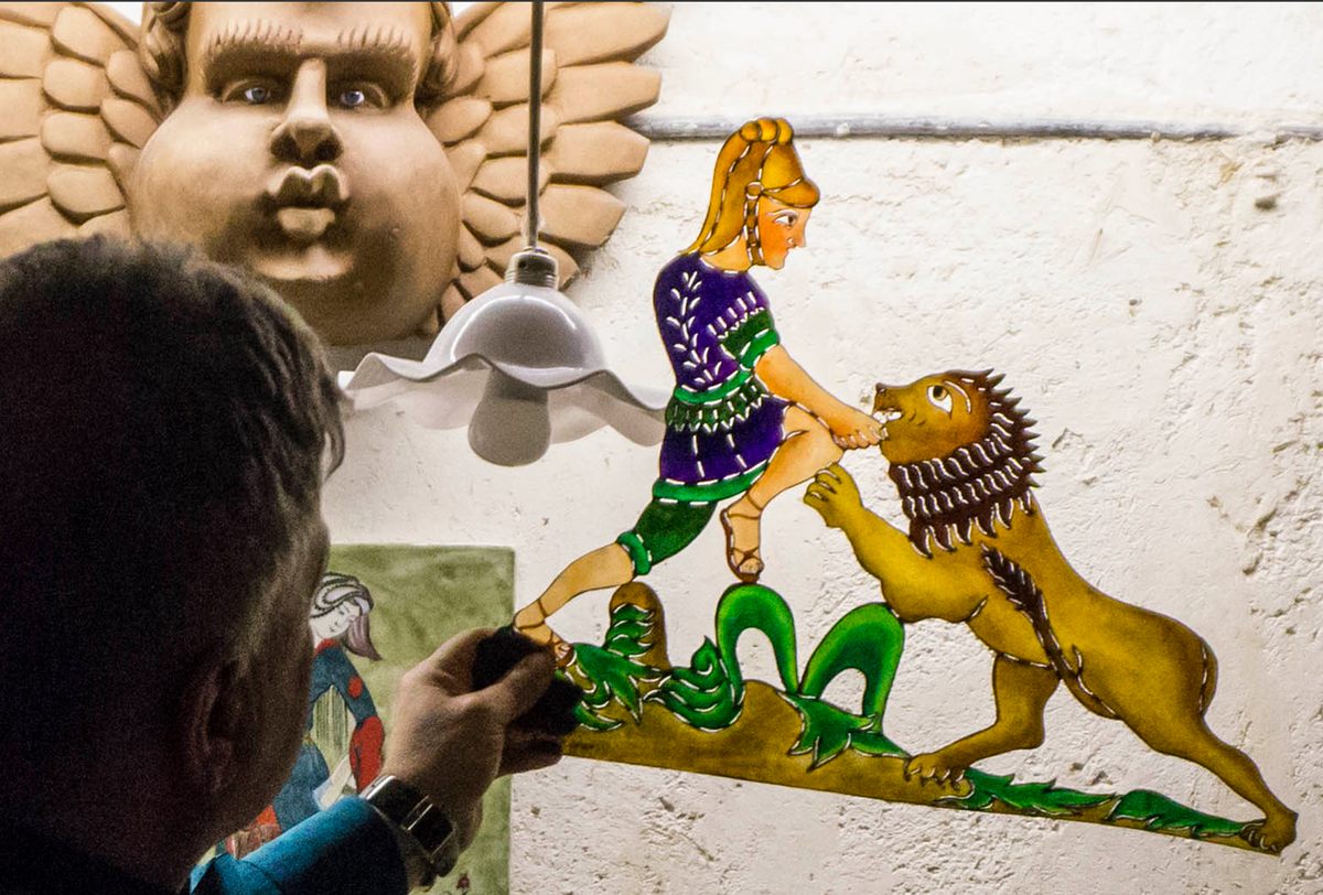 Özek holds a figure which depicts Alexander the Great and a lion.