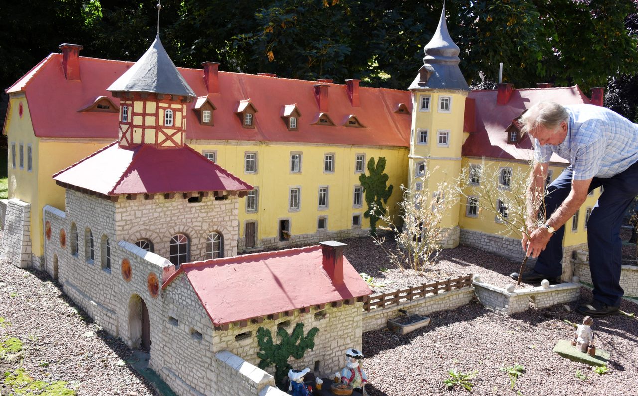 Günther Beinert straightens a mini tree beside one of his 1:10 castles.