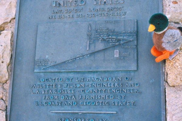 A close-up of the plaque on the historical marker with a plush duck. (Wikimedia Commons)