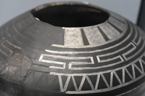 A black clay bowl with silver overlay on display at Latenium.