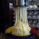 Pressing vanilla ice cream into noodle shape.