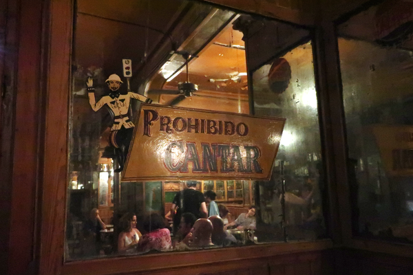 A sign warns patrons that singing is forbidden here.