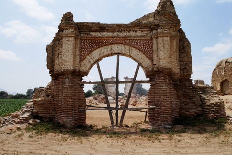 Church ruin layered with centuries of destruction in the distance