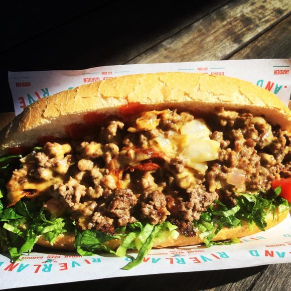 A classic chopped cheese with ground beef, melted cheese, tomato, onion, and lettuce.