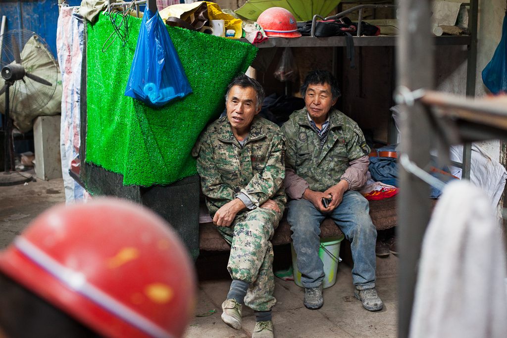 Space is tight and these men share the bottom bunk, leaving the top for their possessions. There is a close bond between the workers, they regard each other “like family”, as one employee puts it.