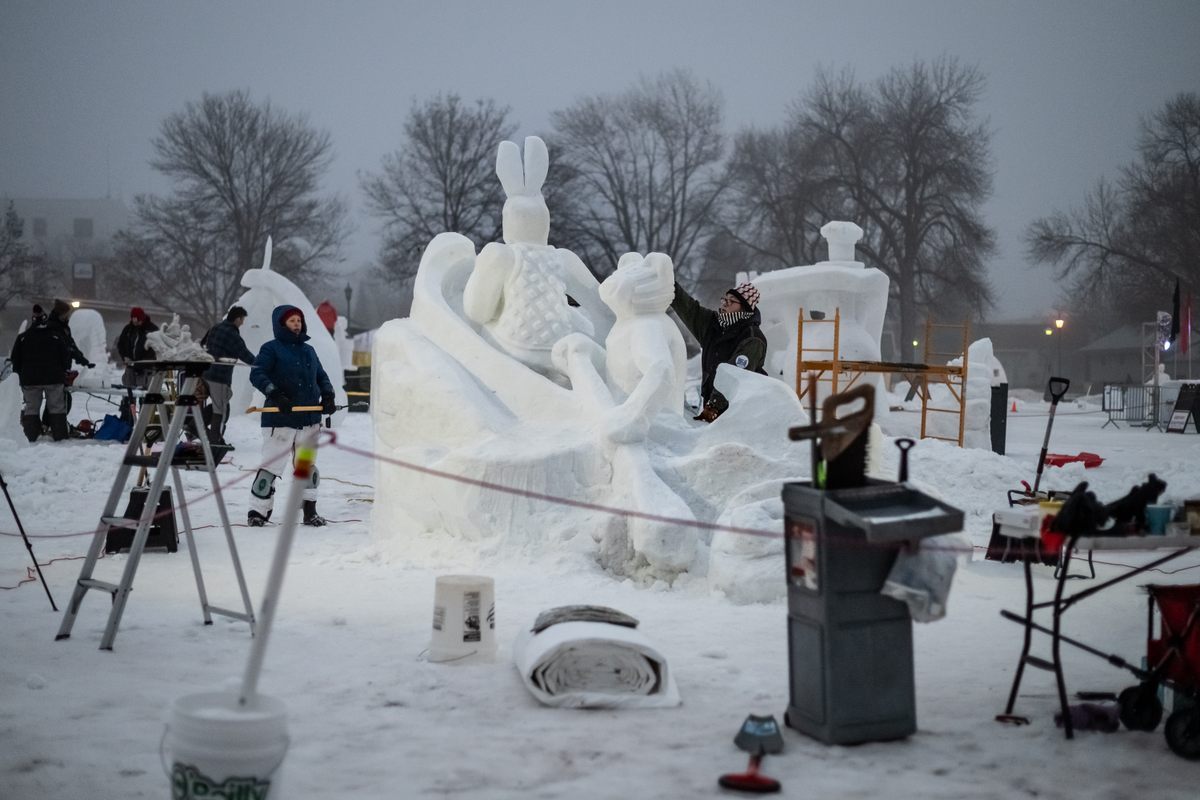 Team Kwe's 2024 sculpture “Wenabozho and Dadibaajimad Journey on the River of Souls,” illustrating a traditional Ojibwe story of two figures—Wenabozho and his brother Dadibaajimad—on an otherworldly journey.
