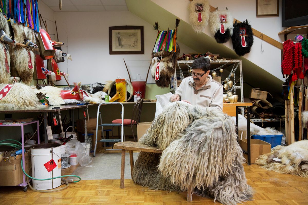 Marko Klinc fixes a Kurent costume in his workshop. Sheepskins are used for the handmade coats and masks. 