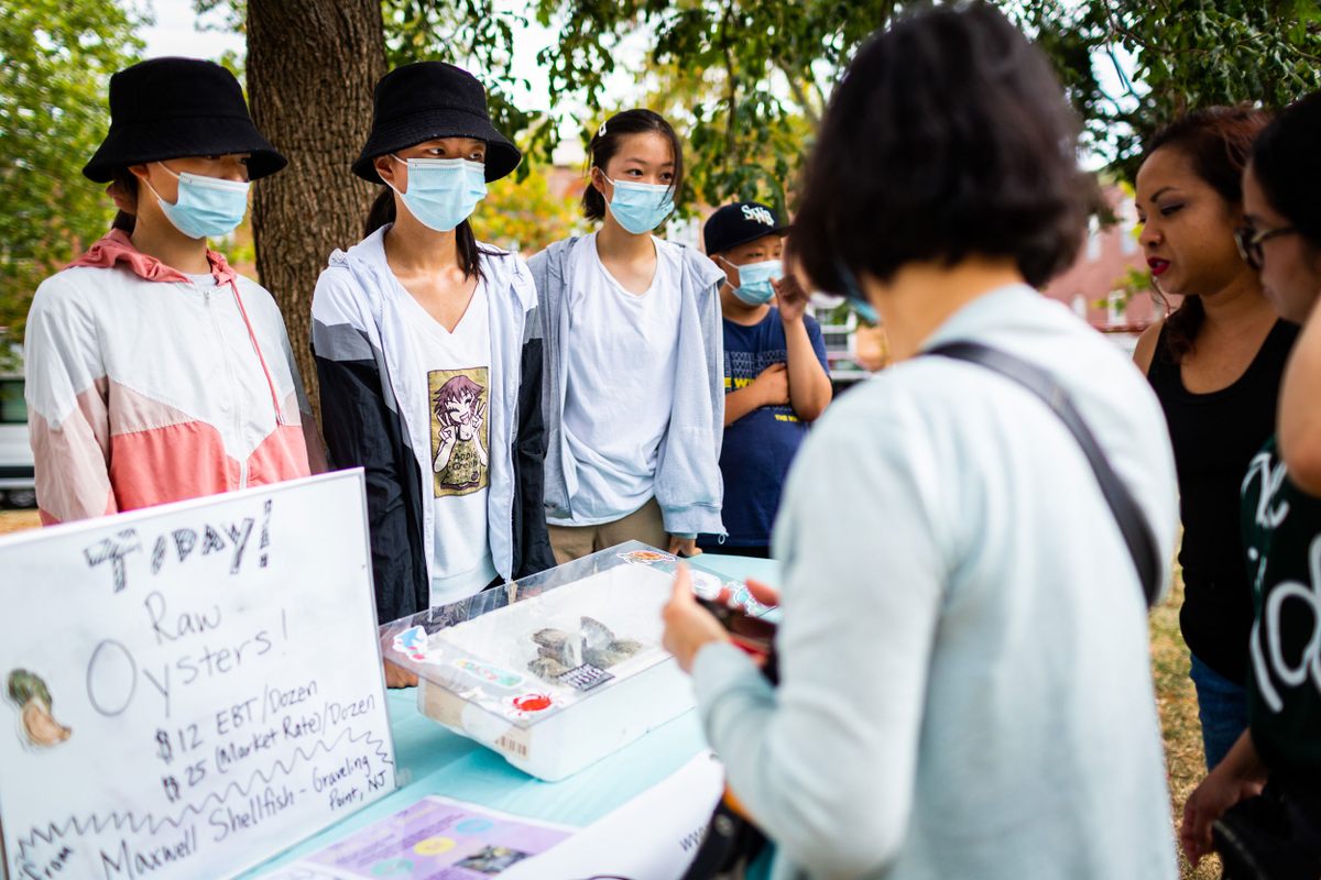 High school students talk with potential customers during the weekly delivery of seafood.