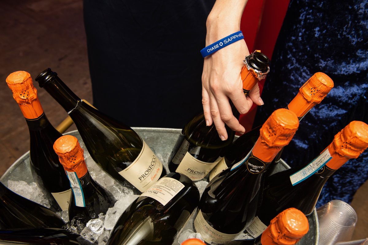 An Atlas Obscura staff member serves bubbly at check-in.