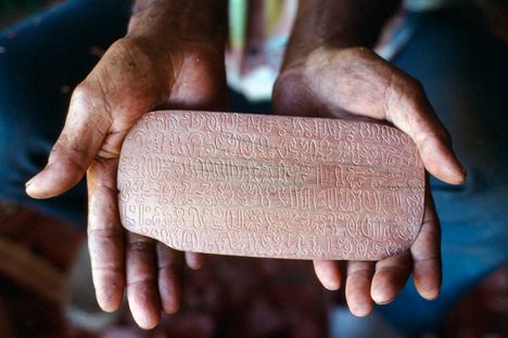 Wood artisan Benedicto Tuki Tepano holding a rongorongo tablet.