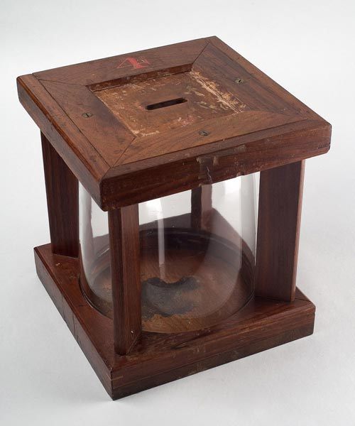 A later version of the glass ballot box with a cylindrical shape.